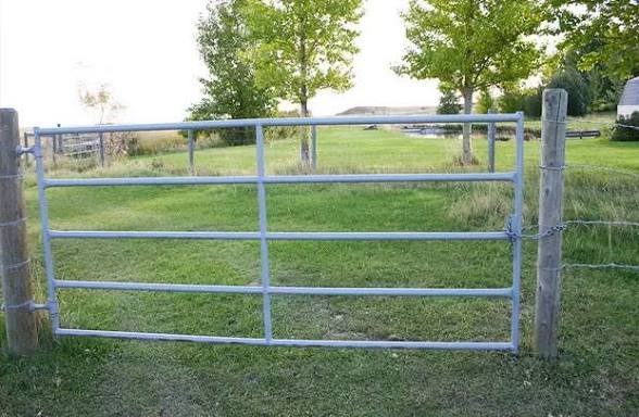 Galvanized tube farm gate hung on wood posts