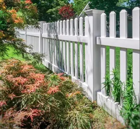 White picket fence beside a garden bed
