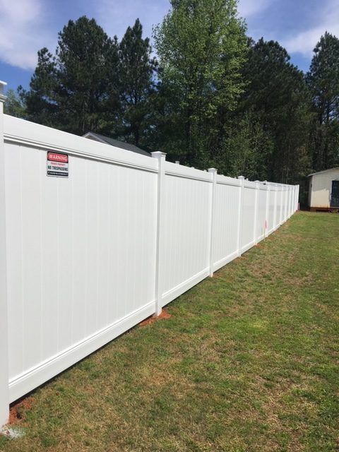 White vinyl privacy fence along a backyard